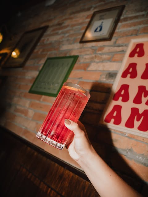 Coquetel vermelho em copo alto no balcão do Mesa Pizza